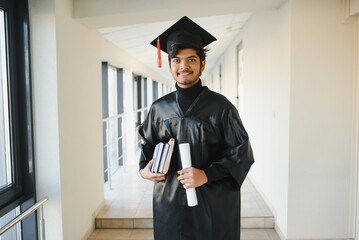 Emotional indian graduate in graduation glow and diploma.