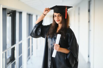 Wall Mural - Young Asian Indian female graduate wearing robe. Achievement in life.Learning with confidence