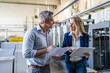 © Westend61 - Businessman and businesswoman discussing together in factory