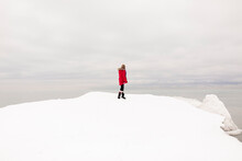 Girl Standing On Snow Looking At View In Winter