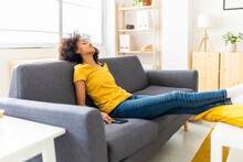 Young Woman Sleeping On Sofa In Living Room At Home