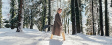 Woman Walking On Deep Snow In Forest