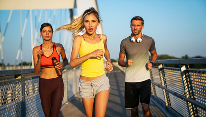 Wall Mural - Fitness sport people running lifestyle concept. Group of young people jogging together outdoors.