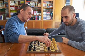 Wise of the older concept. Senior man teaching younger man to play chess