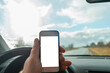 © ARVD73 - Man using blank white screen mobile smartphone inside a car in spring day landscape. copy space for your advertisement,mockup.