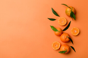 Wall Mural - Many fresh ripe mandarin with green leaves on colored background, top view, space for text