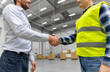 © Syda Productions - logistic business and cooperation concept - close up of manual worker and businessman with clipboard shaking hands and making deal at warehouse