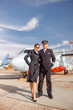 © Kostiantyn - Airplane pilot and stewardess standing outdoors at airport