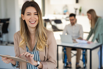 Wall Mural - Portrait of smiling business woman in office working with tablet