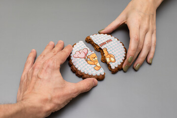 female and male hands connect the two halves of the gingerbread