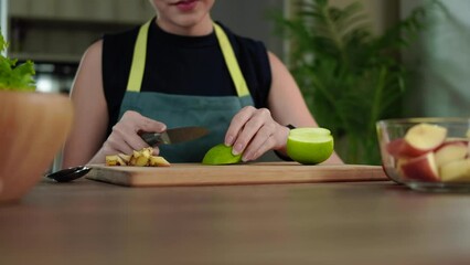 Wall Mural - Asian woman hands holding knife cutting apple for making healthy salad in kitchen. Healthy food concept.