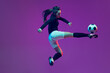 © master1305 - In action. One sportive girl, female soccer player training with football ball isolated on purple studio background in neon light. Sport, action, motion, fitness
