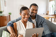 © Rido - Happy mature african american couple using digital tablet at home