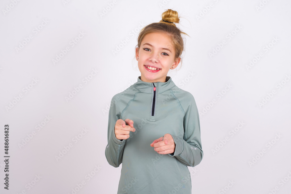 little caucasian kid girl with hair bun wearing technical shirt over ...