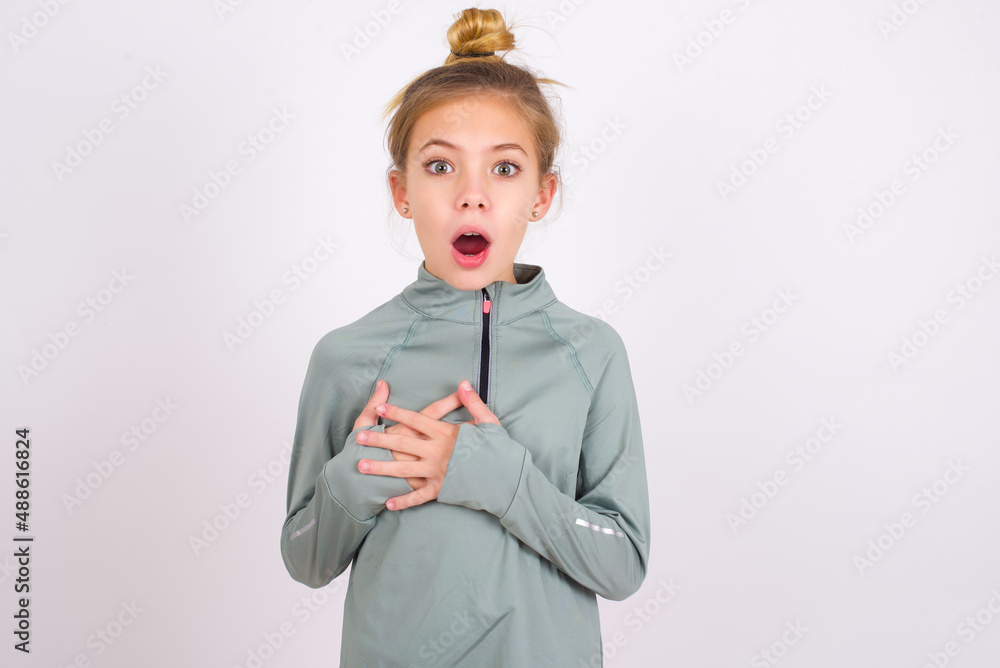 Scared little caucasian kid girl with hair bun wearing technical shirt ...