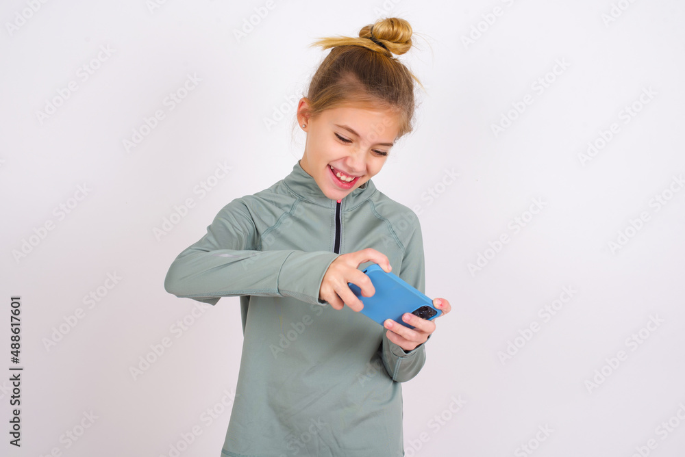 little caucasian kid girl with hair bun wearing technical shirt over ...