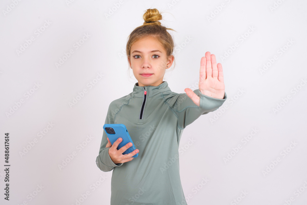 little caucasian kid girl with hair bun wearing technical shirt over ...