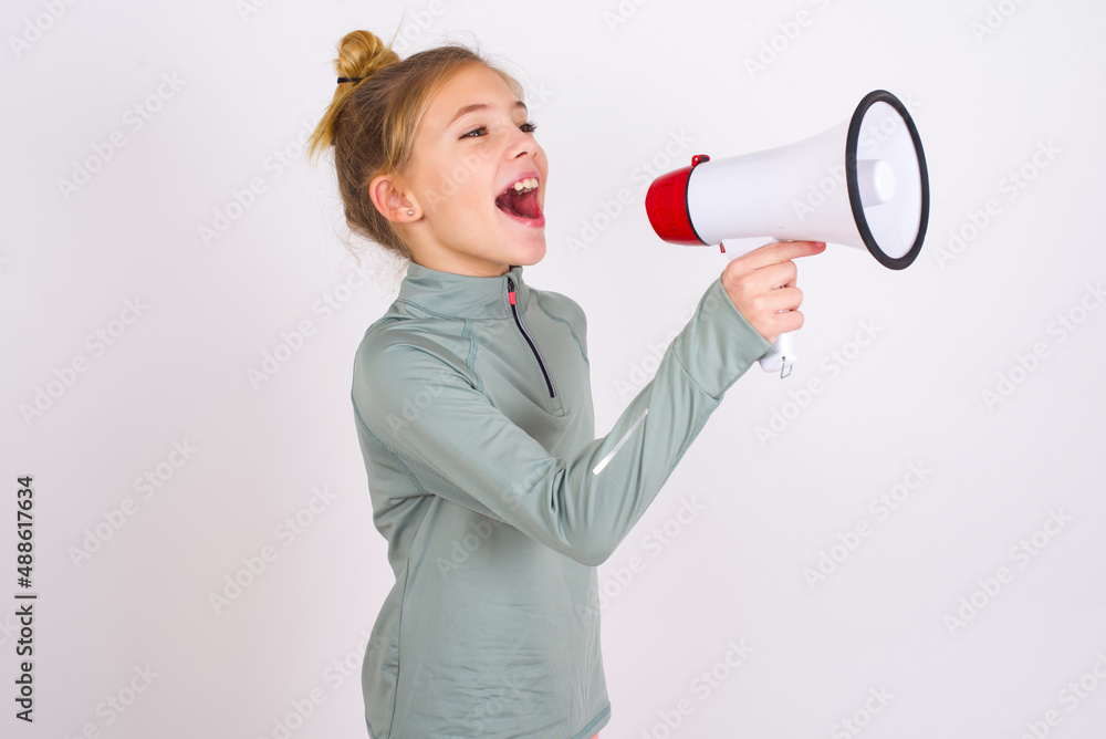 little caucasian kid girl with hair bun wearing technical shirt over ...
