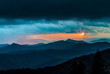 Fototapeta Sawanna - The sun barely peaks out of the clouds before setting over the Blue Ridge Mountains