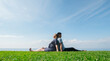 © StockMediaSeller - Asian man with a pregnant woman are resting in nature in a picturesque place, sit on the green grass