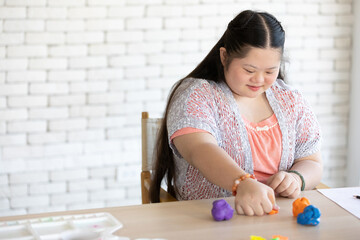 Wall Mural - down syndrome girl sculpt plasticine figures on a table