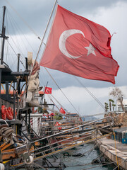 Sticker - The Turkish flag flies over a boat in the old town harbour ,Antalaya ,Turkey .