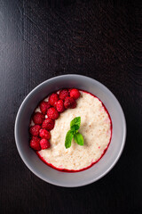 Sticker - oatmeal porridge in ceramic bowl with fresh ripe berries and mint over wooden background