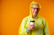 © fotofabrika - Mature man wearing raincoat over yellow background