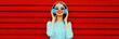 © rohappy - Portrait of happy smiling young woman listening to music in headphones on colorful red background