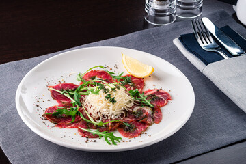 Canvas Print - Carpaccio of beef, tasty Mediterranean appetizer with cheese. beef carpaccio in Italian restaurant