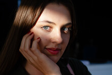 Portrait Shot Of Beautiful Young Woman With Blue Eyes, Lighten By Sun Ray Looking At The Camera
