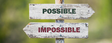 Opposite Signs On Wooden Signpost With The Text Quote Possible Impossible Engraved. Web Banner Format.