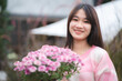 © chokniti - young happy woman person smiling with pink flower blooming, pretty cute girl portrait in summer with nature flower plant in pink color and colorful natural outdoor