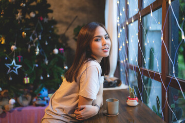 young Asian woman are happy and enjoy to celebrate for Christmas eve in cafe, Christmas party light background showing in coffee cafe