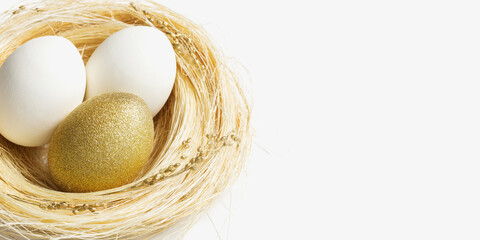 Wall Mural - Easter golden and white eggs in straw nest on white background. Trendy bright egg for spring holiday. Sparkle Easter minimal creative composition Happy Easter spring holiday