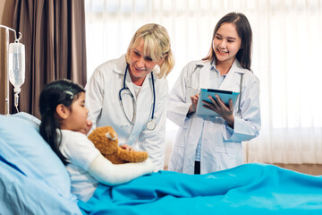 Asian smiling woman doctor service help support discussing and consulting talk to little girl patient give teddy bear and check up information in hospital