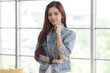 © Bangkok Click Studio - Portrait closeup shot of Asian young beautiful long brown hair female teenager fashion model in casual blue street denim jeans jacket standing smiling look at camera holding hand at chin crossed arm