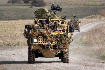 British army Supacat Jackal 4x4 rapid assault, fire support and reconnaissance vehicle in action on a military battle training exercise, Wiltshire UK