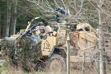 Soldier Sitting In A British Army Supacat Jackal 4x4 Rapid Assault, Fire Support And Reconnaissance Vehicle In Action On A Military Battle Training Exercise, Wiltshire UK