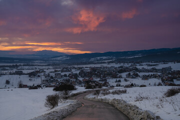 Wall Mural - mountain road in snowy winter during a magnificent sunset