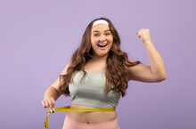 Happy Excited Plus Size European Young Lady In Sportswear Measure Waist With Measuring Tape, Celebrate Victory