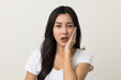 © Chanakon - Asian woman puts her hand on her mouth and feels toothache because of tooth decay. Problems with teeth bad breath. Asian woman around 25 standing on isolated background