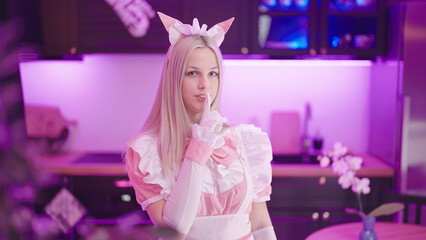 Wall Mural - Cute blonde pink maid cosplay in kitchen gesture to the camera to be quiet