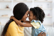 © Prostock-studio - Loving Family. Cute Little Black Girl And Her Mother Embracing At Home