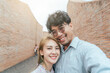 Happy Asian couple traveler take a photo selfie in love and travel coliseum architecture at Surin Thailand after recovered from pandemic coronavirus. Travel trip concept after pandemic COVID-19