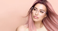 Women eyewear. Beautiful young woman in clear glasses and fashionable colored pink hair, sexy lips and nude makeup. Fashion eyewear and clear vision concept