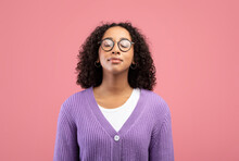 Calm Young Black Woman In Glasses Closing Her Eyes, Breathing Freely On Pink Studio Background