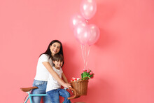Little Son And His Mother With Bicycle And Balloons On Color Background