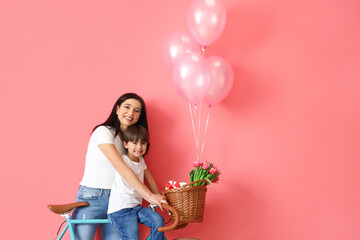 Poster - Little son and his mother with bicycle and balloons on color background