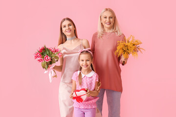 Canvas Print - Young woman with her little daughter, mother and gifts on pink background